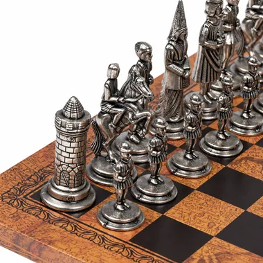 Detalhe das peças prateadas do jogo Camelot, cavalos e torre sobre o tabuleiro em pele sintética