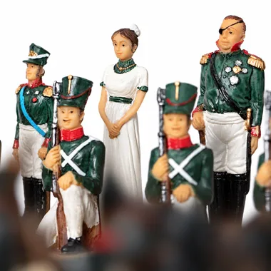 Peças de xadrez com soldados de uniforme verde e dama de vestido branco