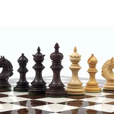 Pièces d'échecs en bois de buis et bois de rose alignées sur l'échiquier