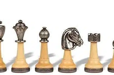 Pormenor das peças em madeira clara e metal prateado, rei, dama, cavalo e peão