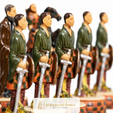 Peças de xadrez em fila representando guerreiros escoceses em kilt armados com espadas