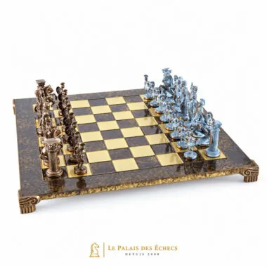 Tabuleiro de xadrez metálico com peças bronze e azuis frente a frente, vista geral angular