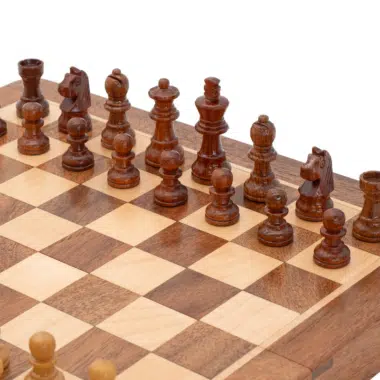 Vue rapprochée des pièces noires en bois sur le plateau de jeu d'échecs - Le Palais des Echecs