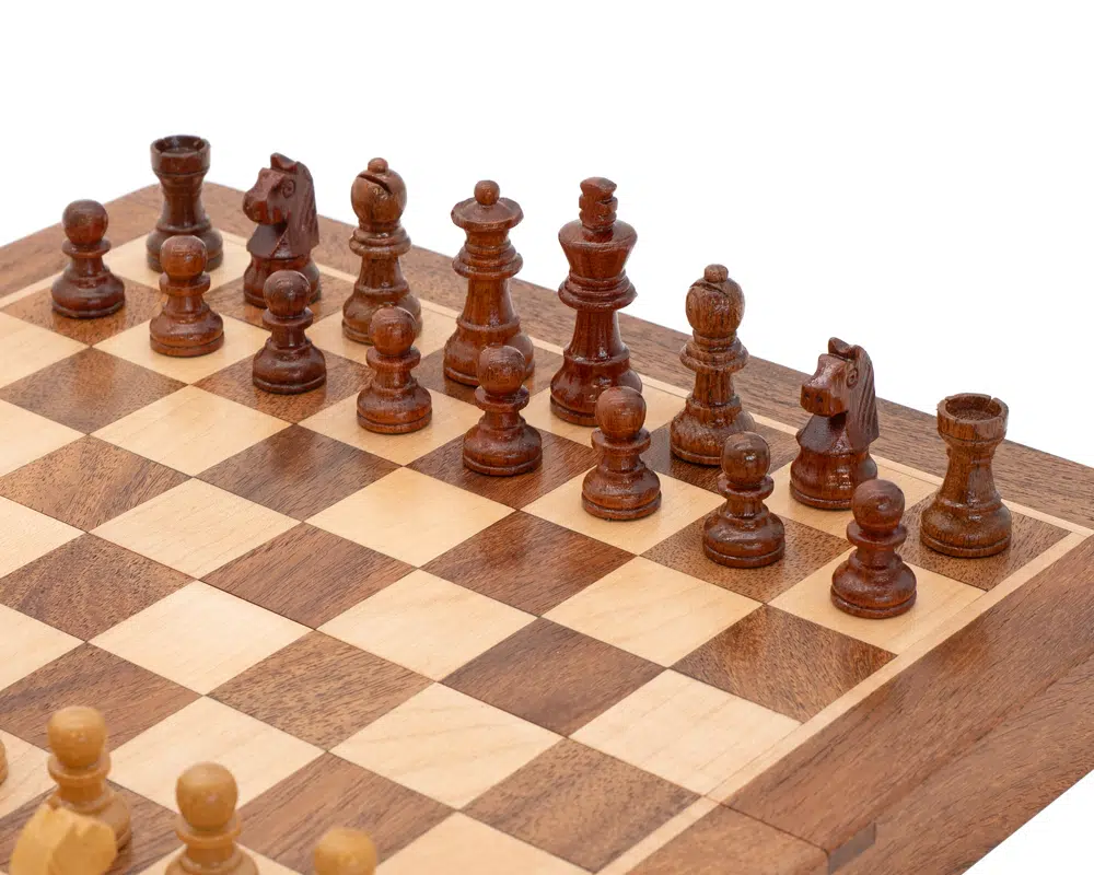 Vue rapprochée des pièces noires en bois sur le plateau de jeu d'échecs - Le Palais des Echecs