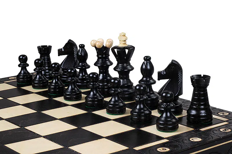 Jeu d'échecs avec pièces noires en position de départ sur plateau élégant